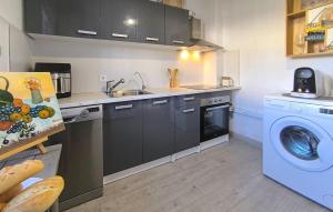 a kitchen with a sink and a washing machine at Cozy Home In Guillena in Guillena