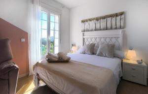 a bedroom with a white bed with a large window at Cozy Home In Guillena in Guillena