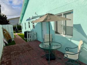 a table with an umbrella on a brick patio at Seashell 5 in Boynton Beach