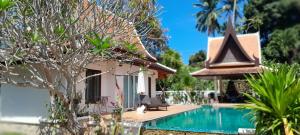 a villa with a swimming pool next to a house at Villa Ban Tai Zero, Master Bedroom Bungalow in Nathon Bay