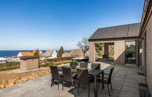a patio with a table and chairs and the ocean at Stunning Home In Hasle With Sauna in Hasle