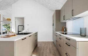 a kitchen with white cabinets and a sink at Stunning Home In Hasle With Sauna in Hasle