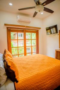 a bedroom with a bed with a ceiling fan and a window at Sanpanchobungalows in San Francisco