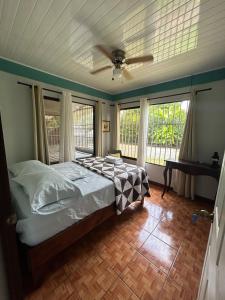 a bedroom with a bed and a ceiling fan at La Esmeralda Villa in Orotina +76 photos