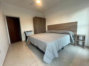 a bedroom with a large bed with a wooden headboard at Costumbres Argentinas Dobles En suite in Avellaneda