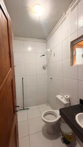 a white bathroom with a toilet and a sink at Cantinho Acolhedor com 4 cama e 2 quartos in Juazeiro do Norte +31 photos