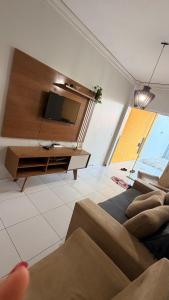 a living room with a tv and a couch at Cantinho Acolhedor com 4 cama e 2 quartos in Juazeiro do Norte