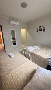 a hotel room with two beds and a mirror at Cantinho Acolhedor com 4 cama e 2 quartos in Juazeiro do Norte