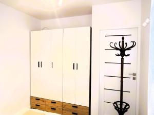 a closet with white cabinets and a pole next to it at New apartment in Wise ka in Wisełka