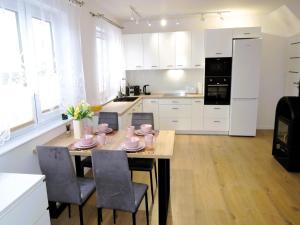 a kitchen with a table with pink dishes on it at New apartment in Wise ka in Wisełka