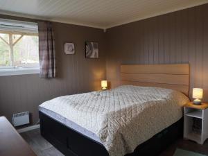 a bedroom with a bed and two lamps on tables at 7 person holiday home in Risør in Risør