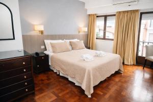 a bedroom with a bed with two towels on it at Gran Hotel Miglierina in Mar del Plata