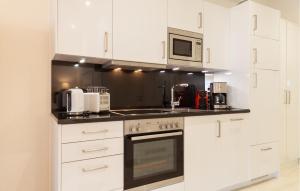 a kitchen with white cabinets and a stove top oven at Baltic in Binz