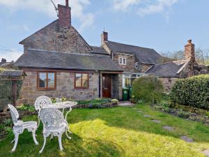a house with two chairs and a table in the yard at 2 Bed in Matlock oc-81116 in Crich