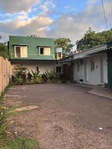a house with a green roof and a driveway at Pousada le sorelle in Rosário do Sul