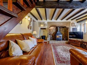 a living room with a leather couch and a fireplace at 2 Bed in Matlock oc-81116 in Crich