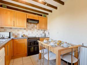 a kitchen with wooden cabinets and a table with chairs at 2 Bed in Matlock oc-81116 in Crich +17 photos