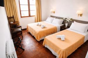 a hotel room with two beds and a chair at Gran Hotel Miglierina in Mar del Plata +38 photos