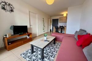 a living room with a pink couch and a table at FARE TEMEAO near ferry dock in Papeete