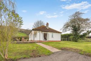 a small white house with a grass yard at 2 Bed in Llangasty oc-d39006 in Llangorse