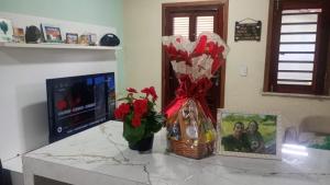 a kitchen counter with a bouquet of flowers and a picture at Aconchego particular in Guaramiranga +7 photos