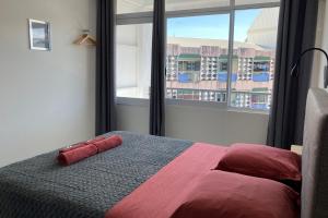 a bedroom with a bed and a large window at TIARE - City center room Papeete in Papeete