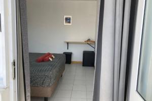 a small room with a bed and a table at TIARE - City center room Papeete in Papeete +8 photos