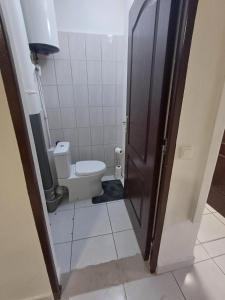 a bathroom with a toilet and a door open at B787 - City center room Papeete in Papeete