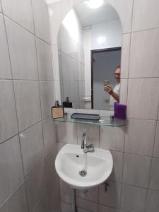 a man taking a picture of a sink in a bathroom at B787 - City center room Papeete in Papeete