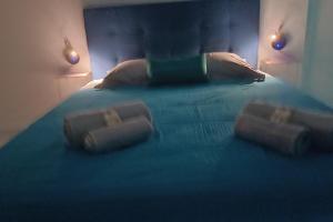 a bedroom with a blue bed with three pillows at B787 - City center room Papeete in Papeete +9 photos