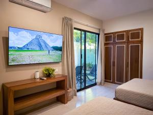 a bedroom with a tv on the wall at Suite Premium con piscina privada en Valladolid - Penca Leonor 12 in Valladolid