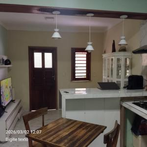 a kitchen with a wooden table and a counter top at Aconchego particular in Guaramiranga