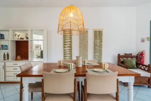 a dining room with a wooden table and chairs at Mont Choisy Lodge 7 Rooms, Large Pool, 2 Min Walk to Beach in Grand-Baie