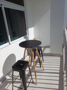 a table and two stools in front of a window at DREAMLINER - City center room Papeete in Papeete