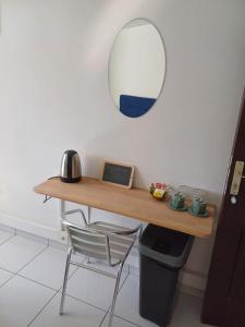 a table with a mirror and a chair in a room at DREAMLINER - City center room Papeete in Papeete +7 photos