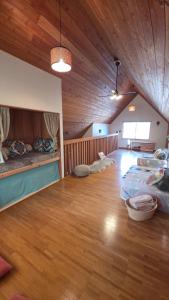 a room with three beds and a wooden ceiling at Cabin Dilusso in Hokuto