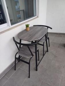 a wooden table and chair with a potted plant on it at HONEY - City center room Papeete in Papeete