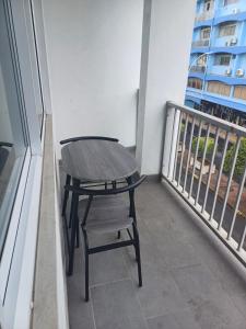 a wooden table and a chair on a balcony at HONEY - City center room Papeete in Papeete +2 photos
