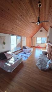 a living room with couches and a wooden ceiling at Cabin Dilusso in Hokuto