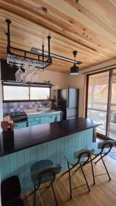 a kitchen with a counter and some chairs in a room at Cabin Dilusso in Hokuto