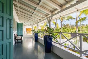 a porch with a green door and plants on it at Mont Choisy Lodge 7 Rooms, Large Pool, 2 Min Walk to Beach in Grand-Baie
