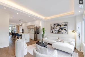 a living room with a white couch and chairs at Toronto Midtown Luxury Living in Toronto