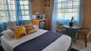 a bedroom with a bed and a table and windows at Smithy's Apartment 2 in Ribishi