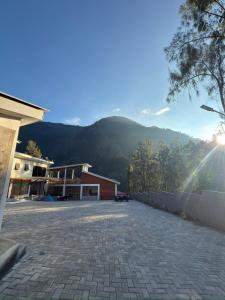 a brick parking lot with a mountain in the background at HLB Homestay in Ngadisari