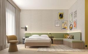 a bedroom with a bed and a desk and a chair at Hampton By Hilton Jeddah Souq7 in Jeddah
