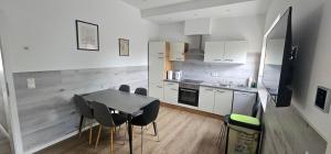 a kitchen with a table and chairs in a room at Gästehof Bützfleth in Stade +27 photos