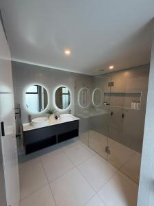a bathroom with two sinks and a shower and mirrors at Darfield Retreat in Darfield +28 photos