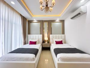 two beds in a room with windows and a chandelier at Cambana Poipet Hotel in Krong Poi Pet +63 photos