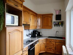 a kitchen with wooden cabinets and a microwave at Le Beau Souvenir, Noiseux in Noiseux
