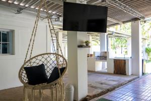 a hanging chair with a television in a room at Brisas del Mar, Costa Azul - Private Pool in Acajutla